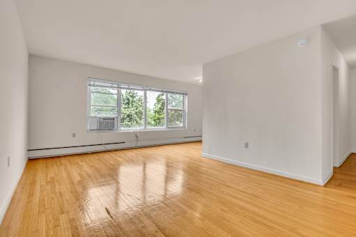 A room with wooden floors and a large window.