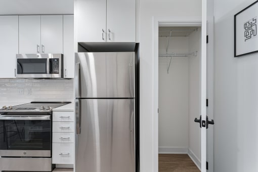 a kitchen with white cabinets and a stainless steel refrigerator