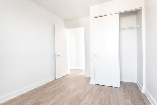 a bedroom with a medium hardwood floor and white walls