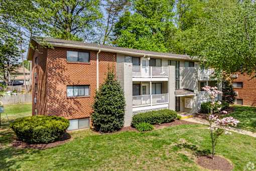 A brick apartment building with a green lawn in front.