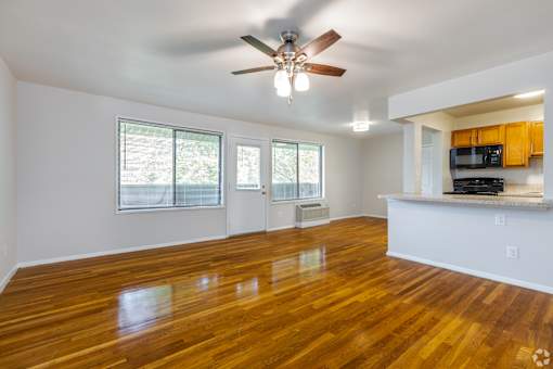 A room with wooden floors and a ceiling fan.