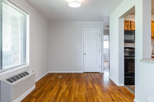 A room with a white door and a window with blinds.
