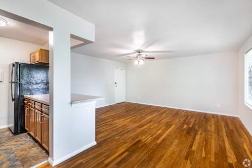 A kitchen with wooden floors and a ceiling fan.