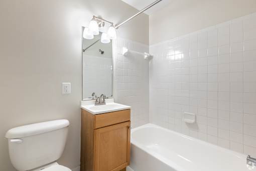 A white bathroom with a white tub, sink, and toilet.