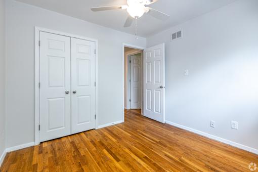 A room with a ceiling fan and two doors.
