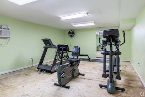 A room with a green wall and exercise equipment.