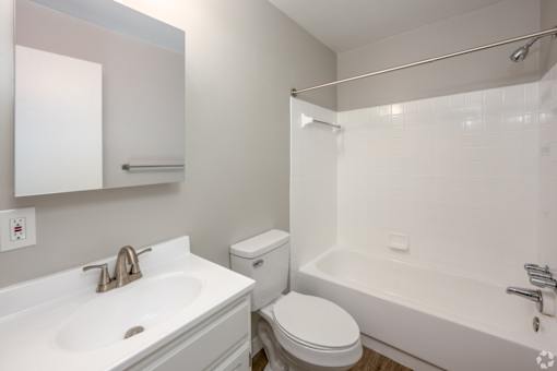 A white bathroom with a sink, toilet, and bathtub.