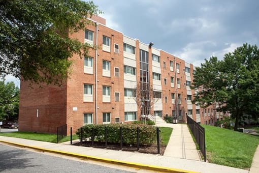 a brick apartment building on the side of a sidewalk