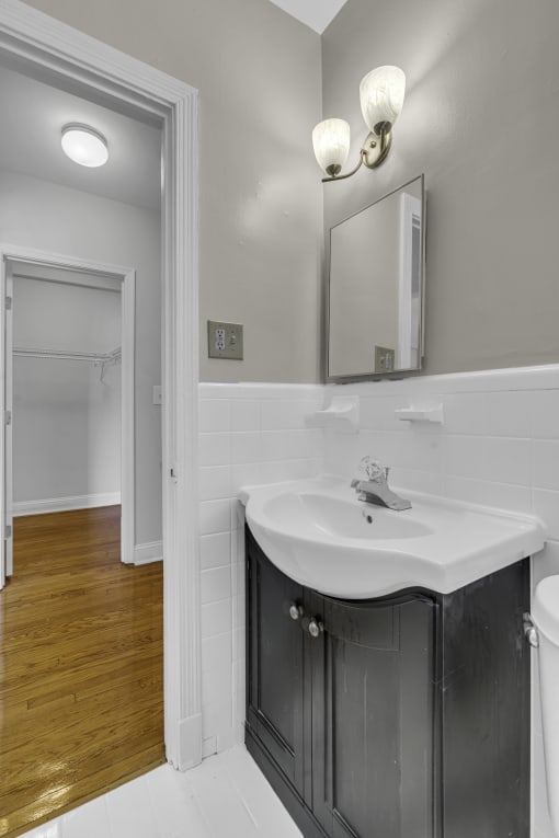 a bathroom with a sink and a mirror and a door to a closet