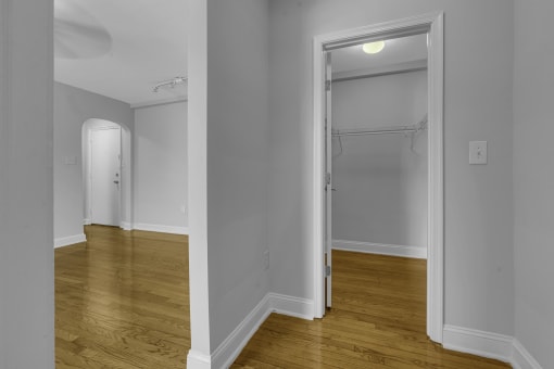 a bedroom with a door to a closet and a hard wood floor