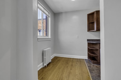 an empty room with a radiator and a window