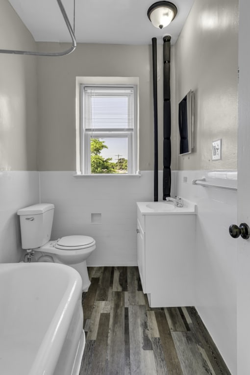 a bathroom with a toilet sink and tub and a window