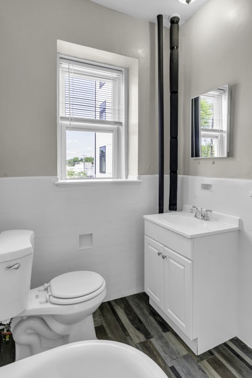 a bathroom with a toilet and a sink and a window