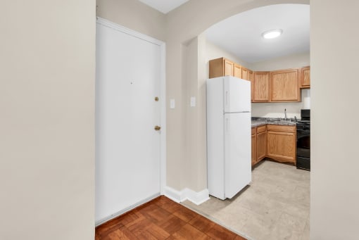 a kitchen with a white refrigerator and wooden cabinets
