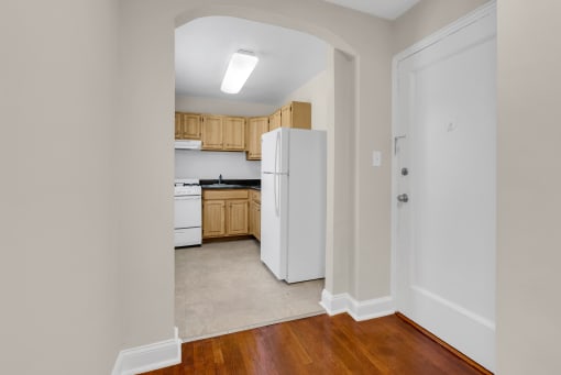 a renovated kitchen with white appliances and wooden cabinets