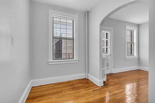 A room with a window and wooden floors.