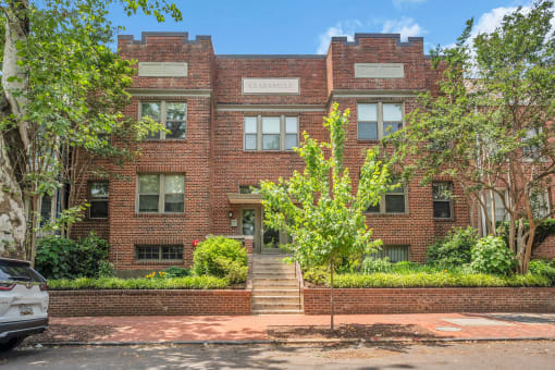 front view of a red brick building with stairs in front