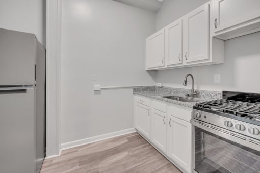 a kitchen with white cabinets and a stainless steel stove and refrigerator