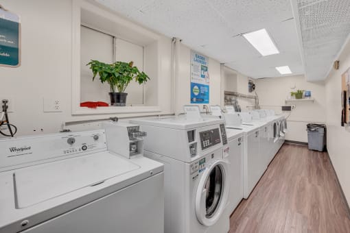 a laundromat with four washers and four dryers in a room with