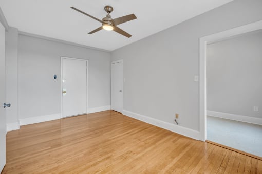 a living room with wood floors and a ceiling fan