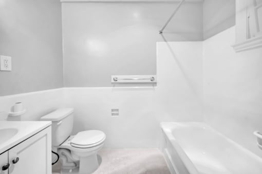 a bathroom with a toilet and a tub and a sink