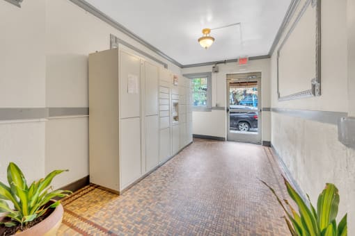 a long hallway with white cabinets and a door to a parking garage