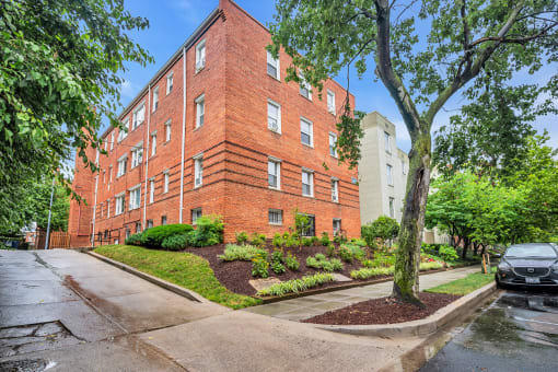 exterior view of a red brick apartment building on a rainy day