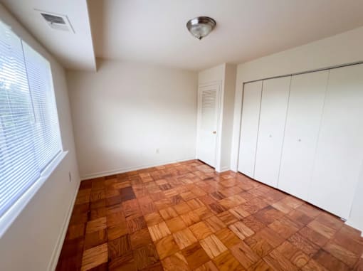 A room with wooden flooring and white walls.