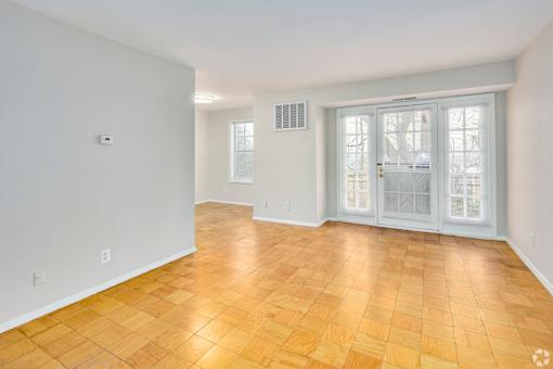 A room with a wooden floor and a sliding glass door.