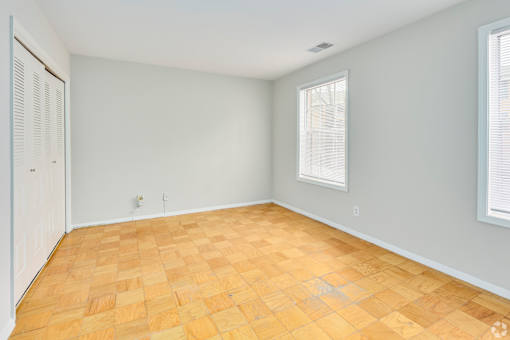 A room with wooden flooring and white walls.