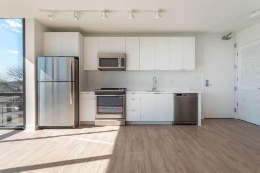 a kitchen with white cabinets and stainless steel appliances