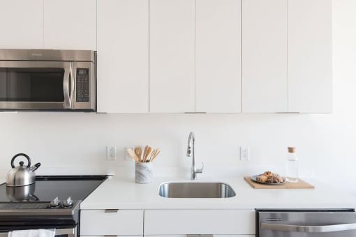 a kitchen with white cabinets and stainless steel appliances