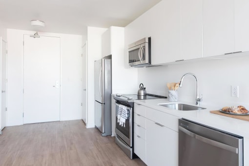 a kitchen with white cabinets and stainless steel appliances