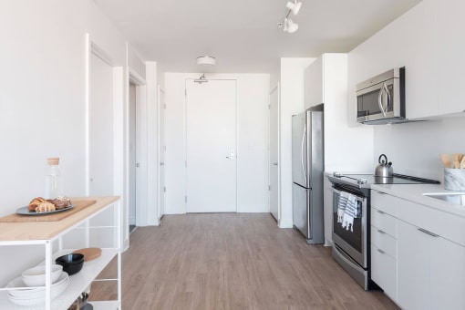 a small kitchen with white cabinets and stainless steel appliances