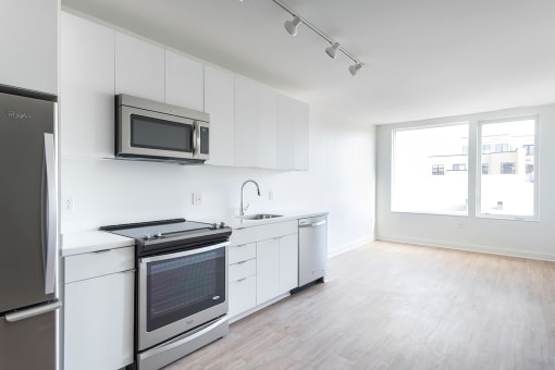 a kitchen with white cabinets and stainless steel appliances