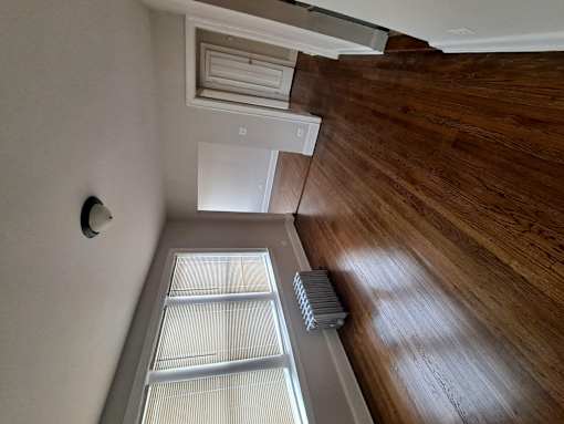 A room with wooden floors and a ceiling fan.