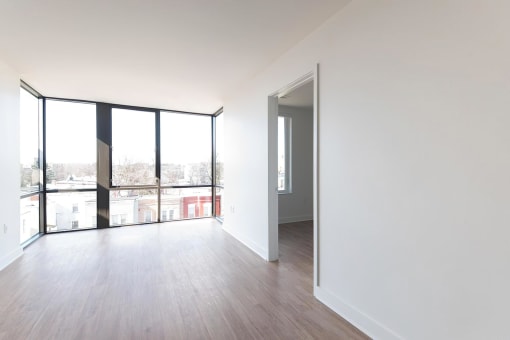 a bedroom with hardwood floors and a large window