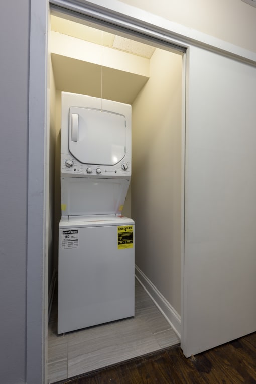 a washer and dryer in a small room with a door to a bathroom
