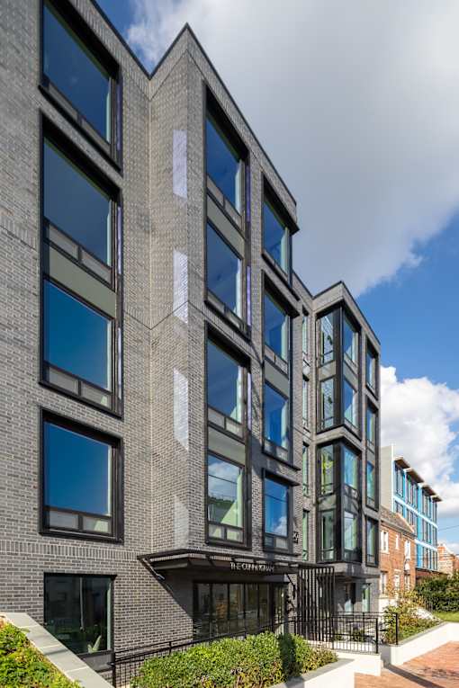 A modern building with a black facade and large windows.