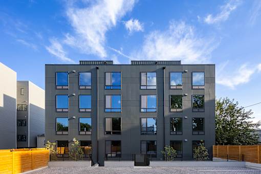 A modern building with a grey facade and large windows.