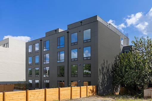 A modern building with a grey facade and multiple windows.