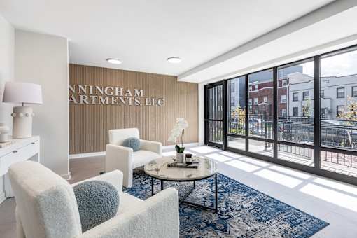 A well-lit room with a table and chairs and a sign that says "Ninningham Apartments LLC".