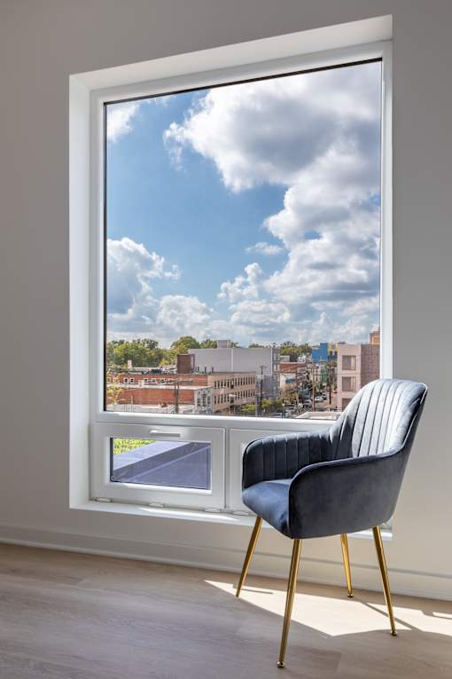A chair is placed in front of a window with a view of the city.