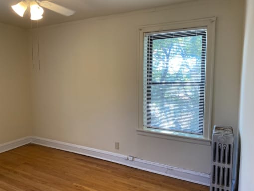 an empty room with a window and a radiator on the floor
