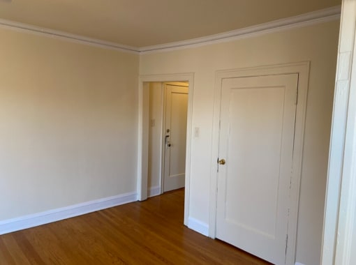 a bedroom with two closets and a door to a hallway