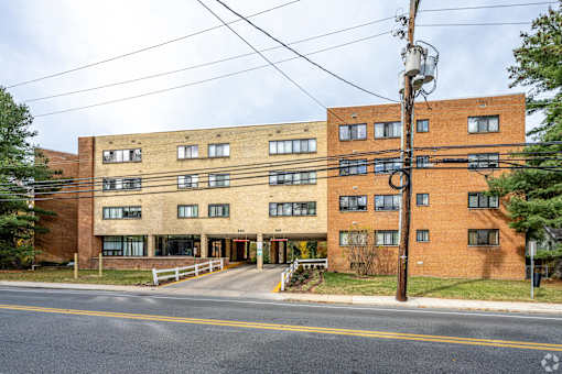 A large brick building with a white fence in front.