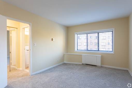 A room with a window and a radiator on the wall.