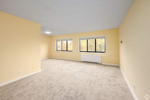 A room with a window and a radiator on the wall.