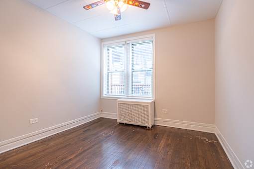 A room with a window and a ceiling fan.
