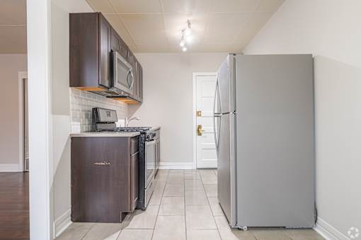 A kitchen with a refrigerator, microwave, oven, and dishwasher.
